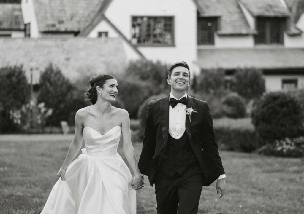 Bride and groom walking hand in hand in front of their wedding venue